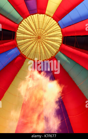 Flame from the gas burner leaps towards the top of a hot air balloon as it inflates for flight. Stock Photo