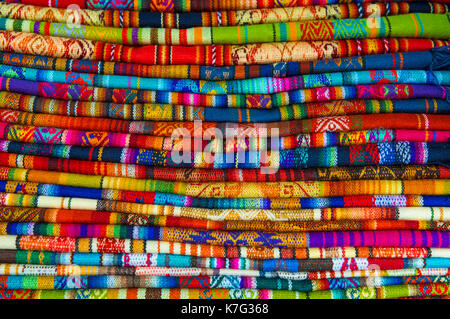 A pile of colorful Andean textiles photographed in the local handicraft market of Cusco, Peru. Stock Photo