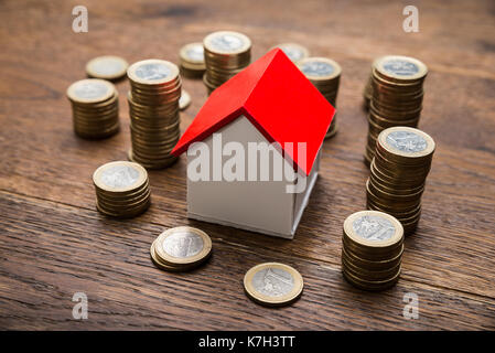 House Of Model With Coins On Wooden Table Stock Photo