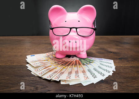 Close-up Of A Piggybank On Euro Banknotes With Eyeglasses Stock Photo