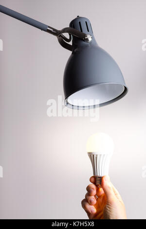 Changing the bulb for led bulb in floor lamp in gray colour. Stock Photo