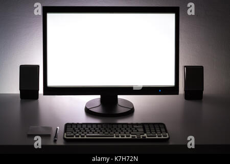 Blank white pc monitor on desktop in organized workplace. Stock Photo