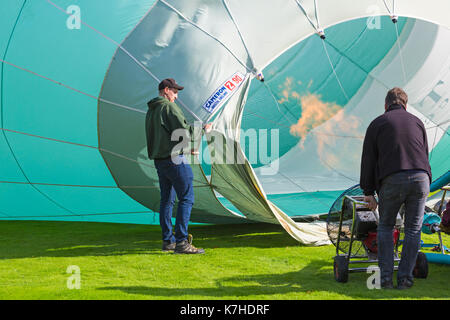 Longleat, Wiltshire UK. 15th September 2017. A mixed day of weather doesn't deter visitors enjoying the Sky Safari hot air balloons at Longleat. Inflating hot air balloon showing flames going inside and inflation fan. Credit: Carolyn Jenkins/Alamy Live News Stock Photo