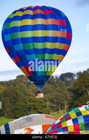 Longleat, Wiltshire UK. 15th September 2017. A mixed day of weather doesn't deter visitors enjoying the Sky Safari hot air balloons at Longleat.  Colourful blue patterned hot air balloon taking off in the air above the trees.  Credit: Carolyn Jenkins/Alamy Live News Stock Photo