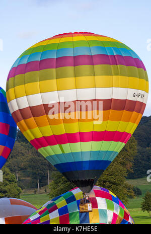 Longleat, Wiltshire UK. 15th September 2017. A mixed day of weather doesn't deter visitors enjoying the Sky Safari hot air balloons at Longleat. Colourful hot air balloon taking off in the air rising above other hot air balloons on  the ground. Credit: Carolyn Jenkins/Alamy Live News Stock Photo