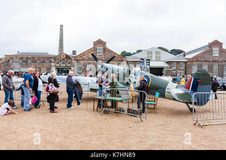 England, Chatham dockyard. Event, Salute to the 1940s. People waiting in line to get their photo taken in the cockpit of a World war two Spitfire fighter plane. Stock Photo