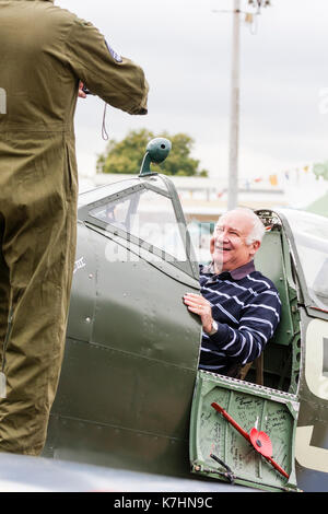 England, Chatham Dockyard. Event, Salute to the forties. Elderly man, smiling while sitting in the cockpit of a Spitfire world war two fighter and posing for a photograph. Stock Photo
