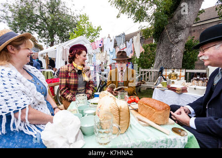 England, Chatham Dockyard. Event, Salute to the forties. Two couples having outdoor picnic together sitting around table chatting. All dressed in upper class 1940 period costume. Stock Photo