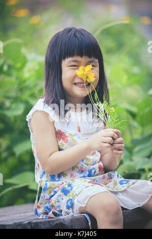 portrait of lovely girl with yellow cosmos flower bouquet in hand toothy smiling face Stock Photo