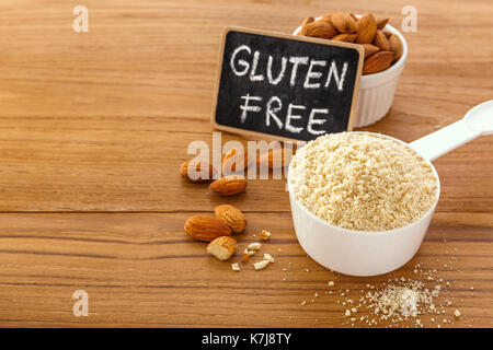 Almond flour with almonds and gluten free sign on wooden table background Stock Photo