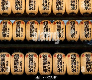 Kyoto, Japan - May 16, 2017: Row of  paper lanterns with Japanese characters along the street to the temple Stock Photo