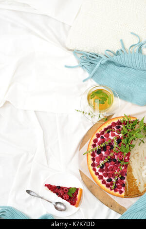 Flat lay breakfast in bed with raspberry cheesecake, mint tea . Window light, space for text blog, posts Stock Photo