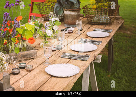 Wooden table setup for garden party or dinner reception. Stock Photo