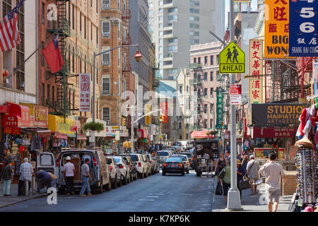 Chinatown street with people and buildings with colorful signs in a sunny day in New York Stock Photo