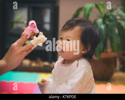 Happy baby girl play puppets with mom Stock Photo