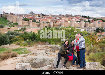 Tourists taking a selfie photograph using smartphone at famous Avila medieval city walls, UNESCO World Heritage Site, Spain Stock Photo