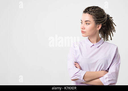Half-length portrait of beautiful woman wearing white blouse looking aside. Stock Photo