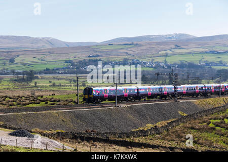 Class 350 electric multiple unit (emu) passenger train operated by FirstTransPennine Express, passing Tebay as it ascends Shap on March 25th 2017, hea Stock Photo