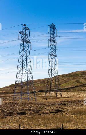 Two dissimilar electricity pylons, part of the national grid, carrying adjacent powerlines over Whatshaw Common on the eastern edge of the Lake Distri Stock Photo