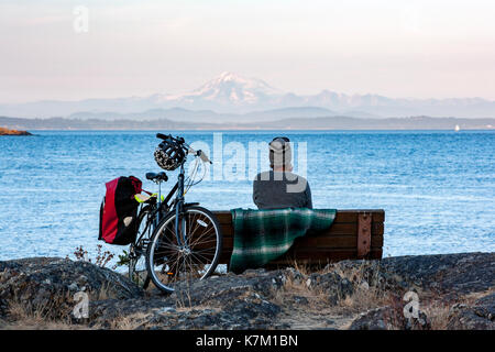Man on bench at Cattle Point, Uplands Park, Oak Bay, Victoria, Vancouver Island, British Columbia, Canada Stock Photo