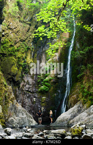 Couple at base of Niagara Falls - Goldstream Provincial Park - Victoria, Vancouver Island, British Columbia, Canada Stock Photo