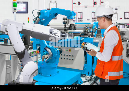 Maintenance engineer programing automated robotic industry 4.0 concept Stock Photo