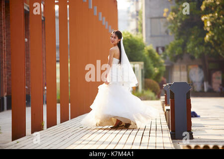 outdoor portrait of young and beautiful asian bride with bouquet in hand. Stock Photo