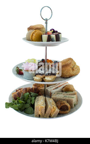 Assortment of high tea delicacies including sandwiches, scones, pies, sweet desserts isolated