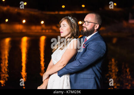 Wedding couple standing by the lake at night Stock Photo