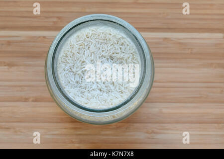 White rice in glass jar on wooden board Stock Photo