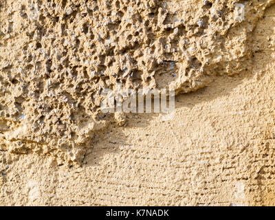 Format filling view old masonry with partially detached rough plaster and clinker stones. Stock Photo