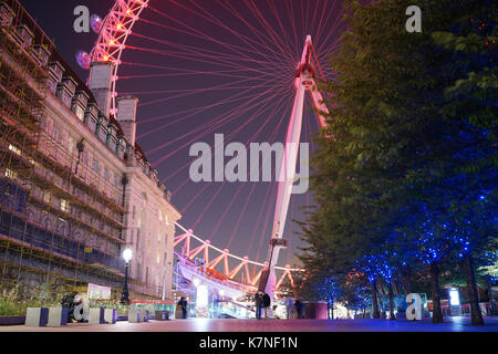 Night time view of the London Eye, with couple in foreground Stock Photo