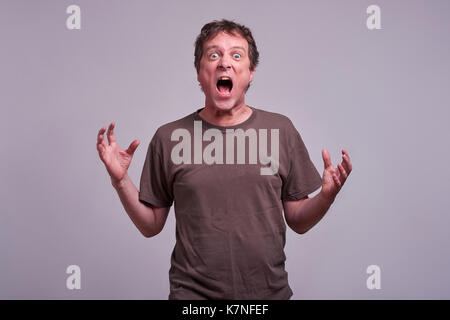 A middle aged man standing and screaming Stock Photo