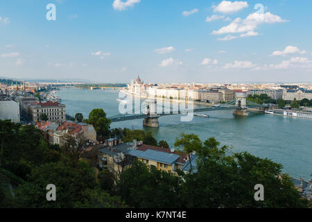 View over Budapest in Hungary with the Chain Bridge over the Danubian in the foreground on a beautiful day with blue sky. Stock Photo