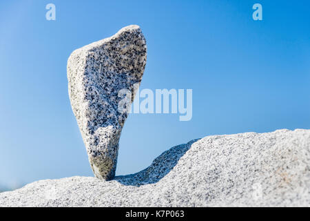 Triangular rock balanced on the tip in Vancouver rock stacking garden Stock Photo