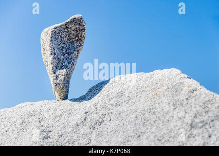 Triangular rock balanced on the tip in Vancouver rock stacking garden Stock Photo