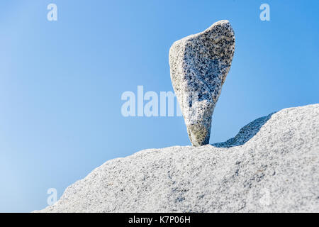 Triangular rock balanced on the tip in Vancouver rock stacking garden Stock Photo