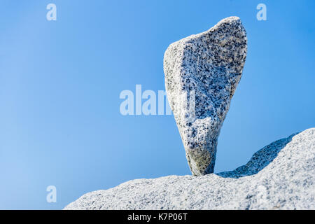 Triangular rock balanced on the tip in Vancouver rock stacking garden Stock Photo