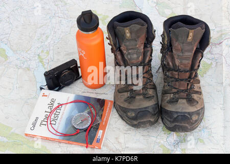 Preparing for a walking holiday in the Lake District. Hiking boots, water flask, camera, guidebook and compass on an Ordnance Survey map of the area Stock Photo