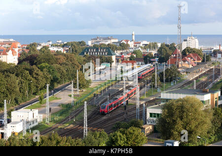 red trains coming out of warnemunde station in germany with the sea as background Stock Photo
