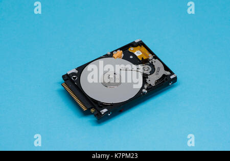 Close-up of an opened computer hard drive disk on blue colored background. Stock Photo