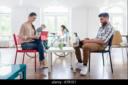 Dedicated young woman editing a document in a modern office spac Stock Photo