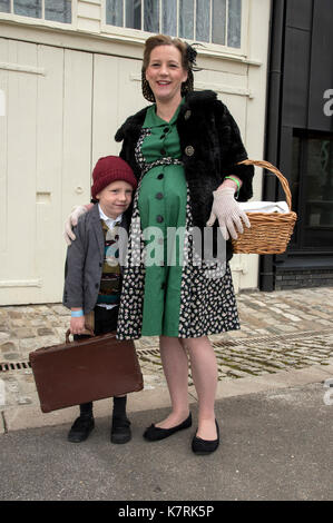Chatham, Kent, UK. 17 September 2017. WWII evacuee Sonny England with mum Nicola, like thousands of war time kids Sonny is evacuating London to the countryside - bringing the past to life with 1940s period dress and world war 2 era cars and planes at the Salute to the 40’s Vintage Weekend at Chatham Historic Dockyard. © Matthew Richardson/Alamy Live News Stock Photo