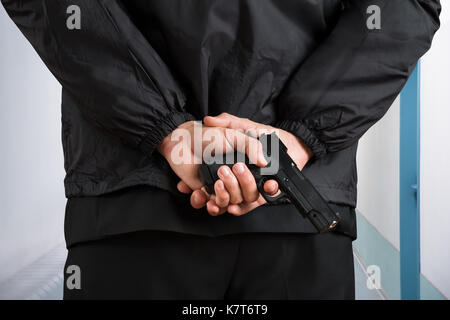 Close-up Photo Of Bodyguard Hands Holding Pistol Stock Photo