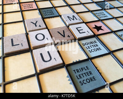 The words 'you love me' spelled out on a Scrabble game board. Stock Photo