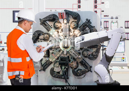 Engineer checking maintenance daily of automated robotic in production line, Industry 4.0 concept Stock Photo