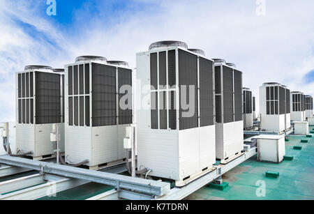 A row of air conditioning units on rooftop with blue sky Stock Photo