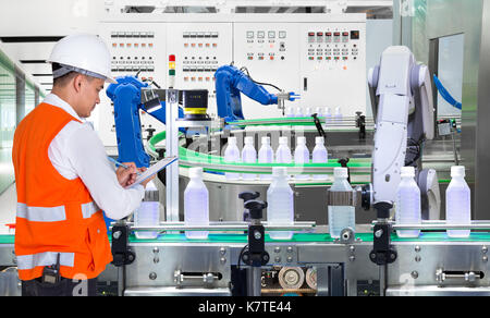 Engineer checking automated robotics in drinks production plant of factory Stock Photo