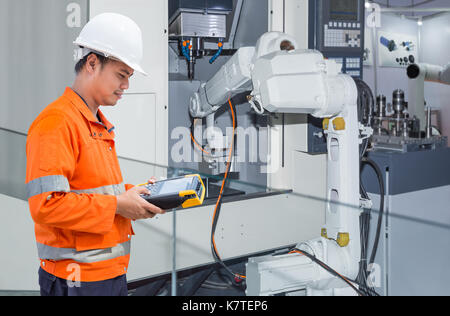 Engineer programming automatic robotic hand machine tool with CNC machine in automotive industry Stock Photo
