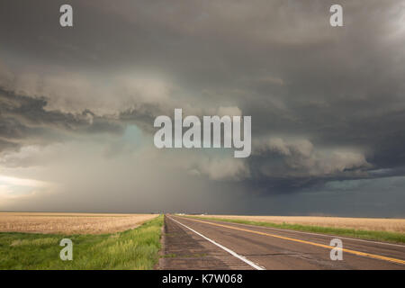 A powerful supercell thunderstorm looms over the highway in eastern Colorado. Stock Photo